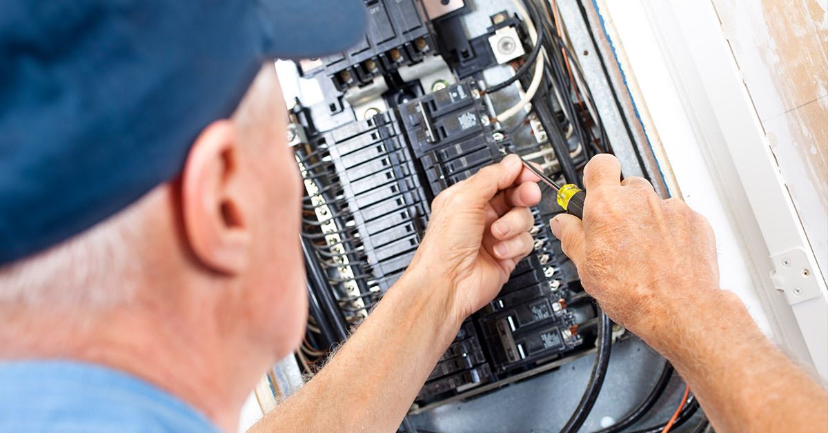 electrician working on circuit breaker panel